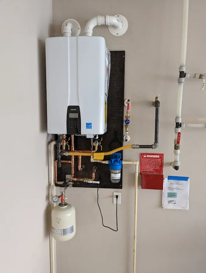 Professional plumber installing copper piping in a Columbine home